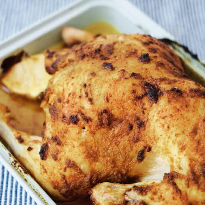 Moroccan roast chicken cooked in a roasting pan from above.