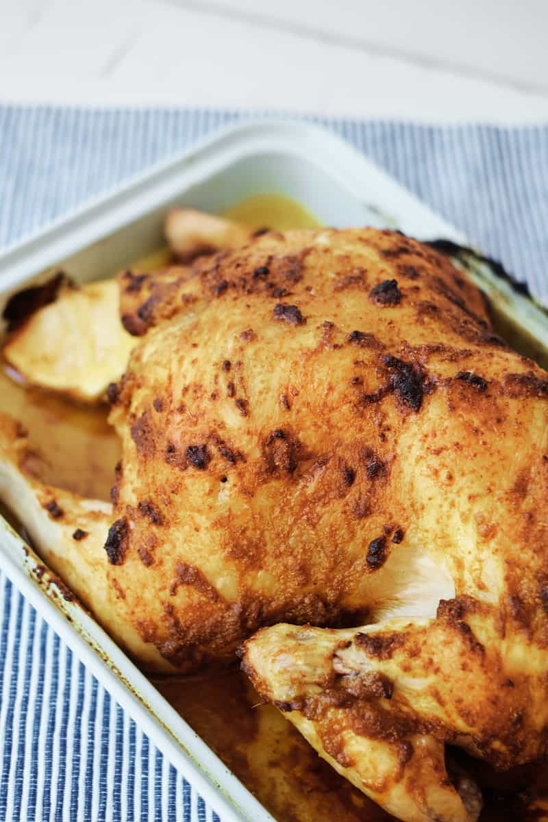 Moroccan roast chicken cooked in a roasting pan from above.