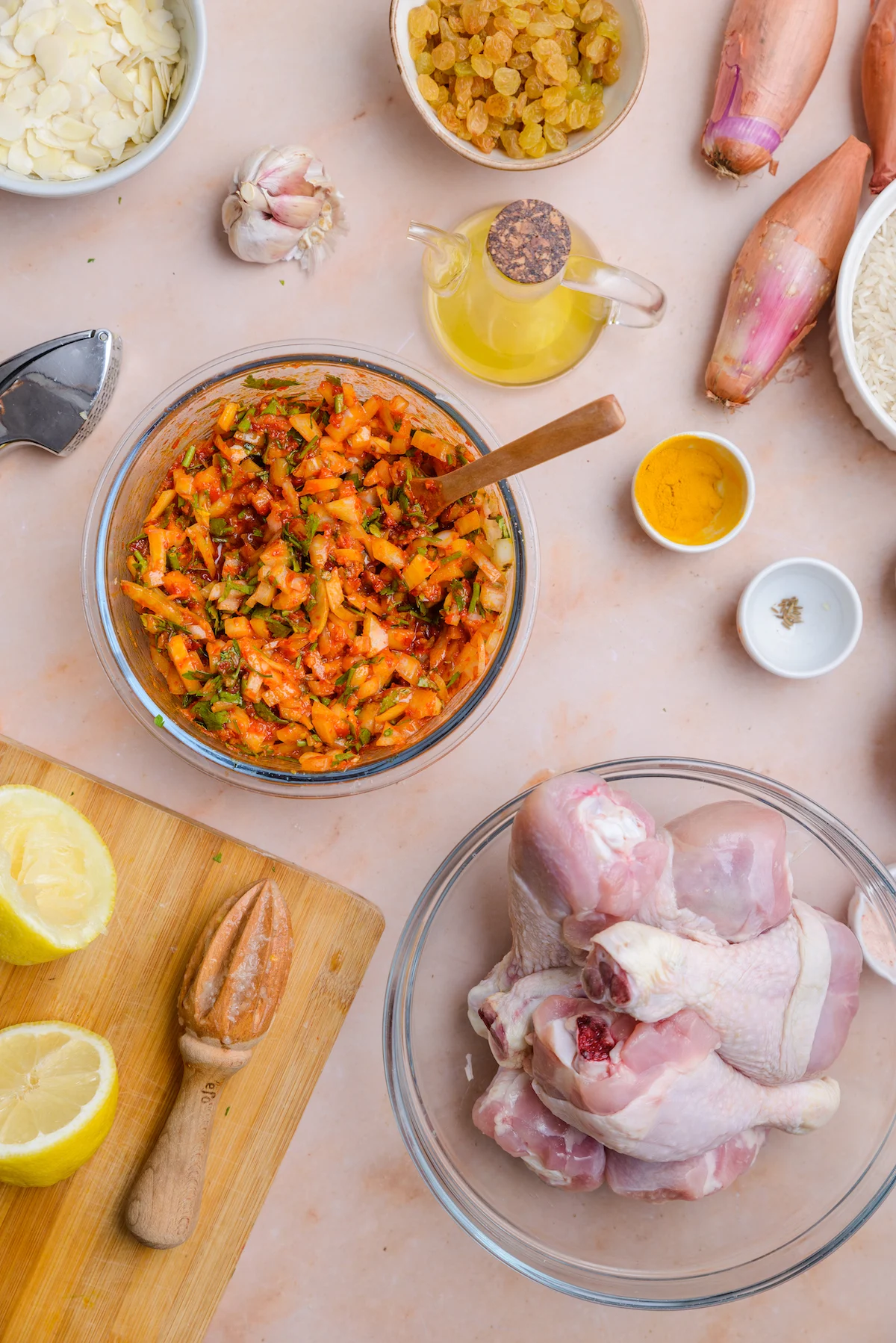 Chicken in a marinade sits on the countertop with the other ingredients for the dish surrounding it.