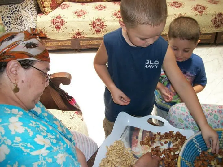 Boys helping grandma shell almonds