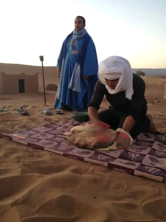 Cleaning off bread in the Sahara Desert