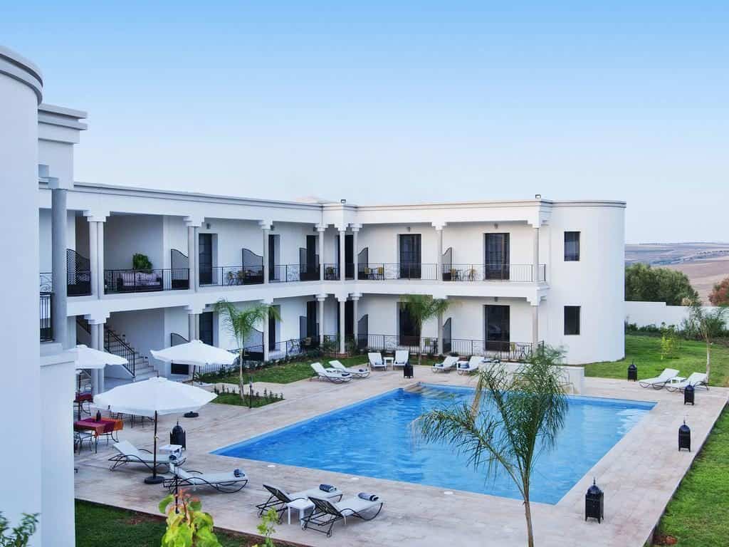 A large white two story building wraps around a central pool.