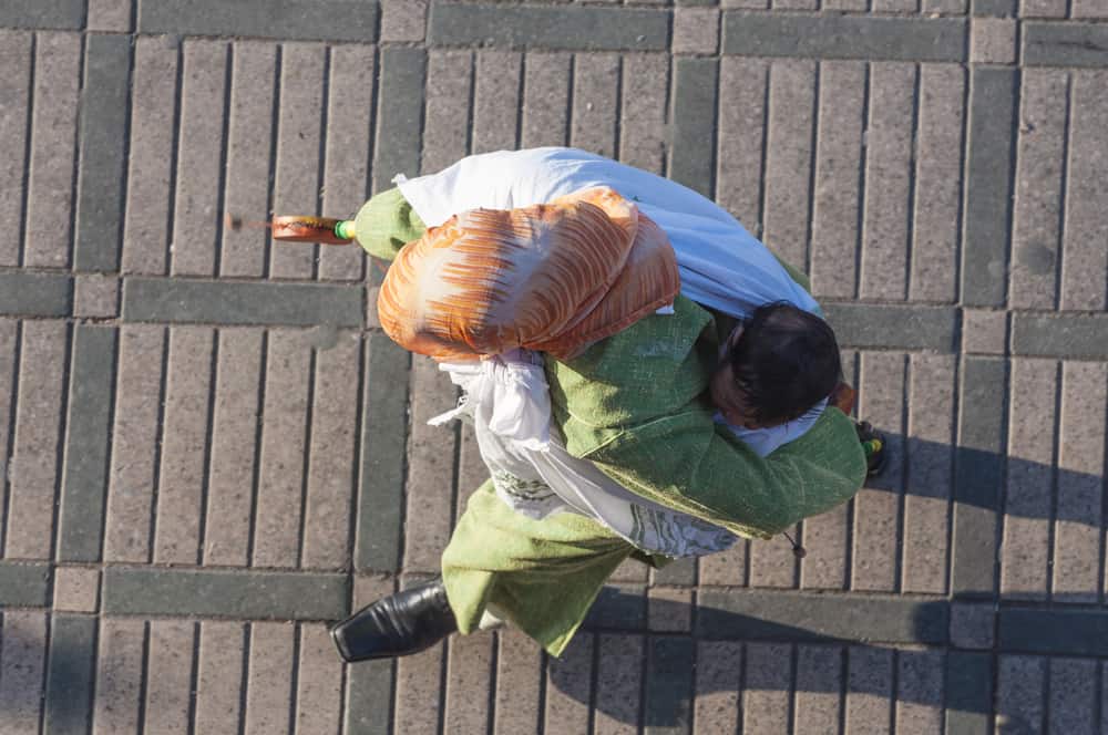 Top shot of a Moroccan woman walking with a baby strapped to her back