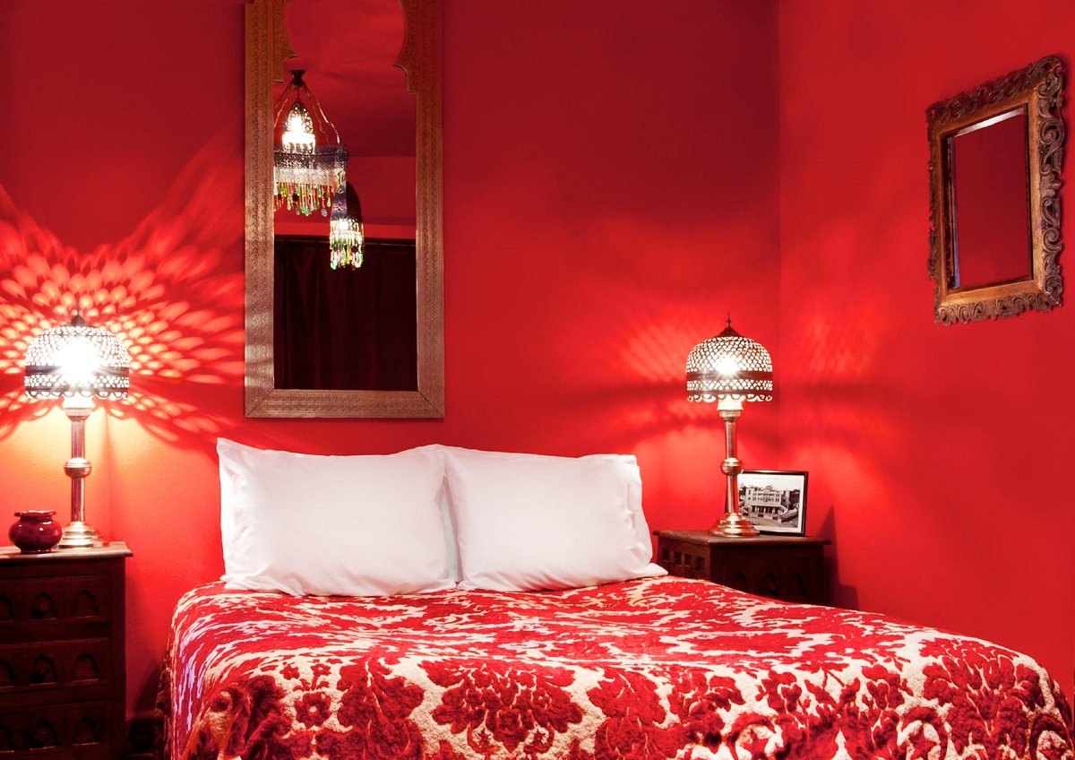 A suite at Dar Nour with red painted walls and red floral-patterned bedsheets