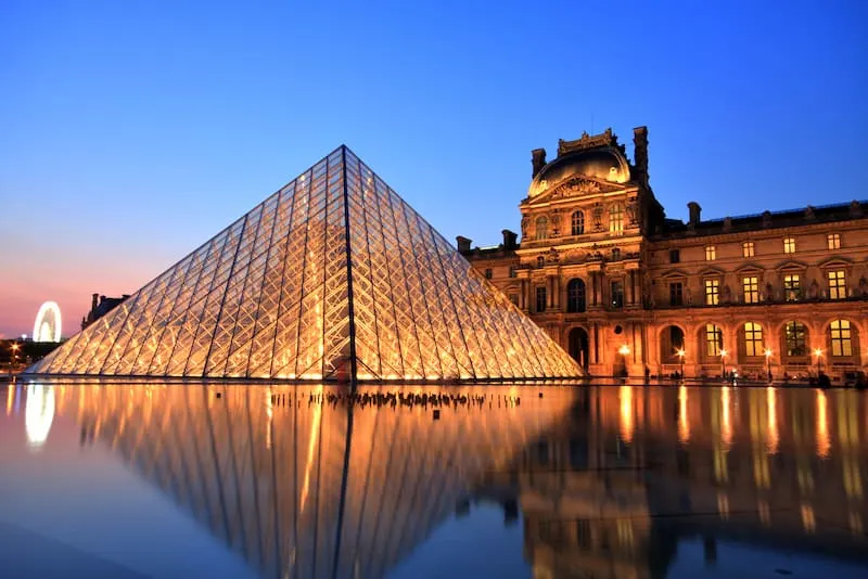 Louvre Pryramid lit up at night in Paris France