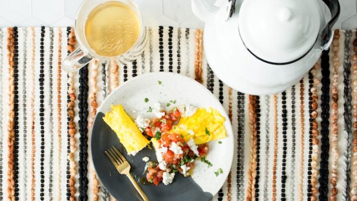 French rolled omelette on a plate with a glass of mint tea and a tea pot of mint tea