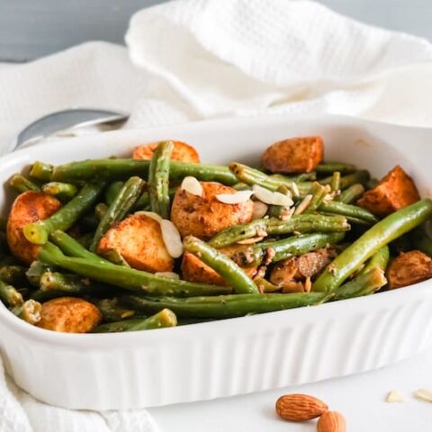 White serving dish with mixed paprika potatoes and green beans