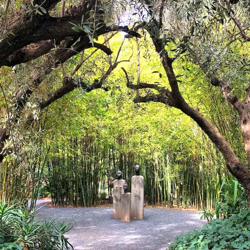 Three statues sit inside a bamboo clearing