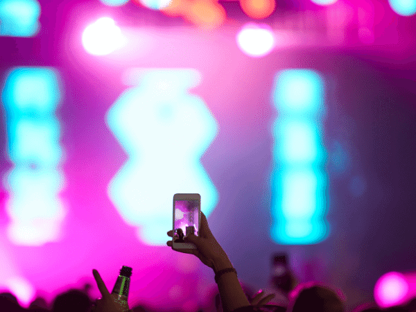 Hand holding a cell phone with a florescent stage