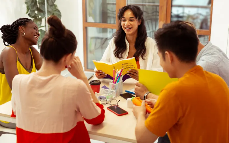 A group of adults is in a circle studying English