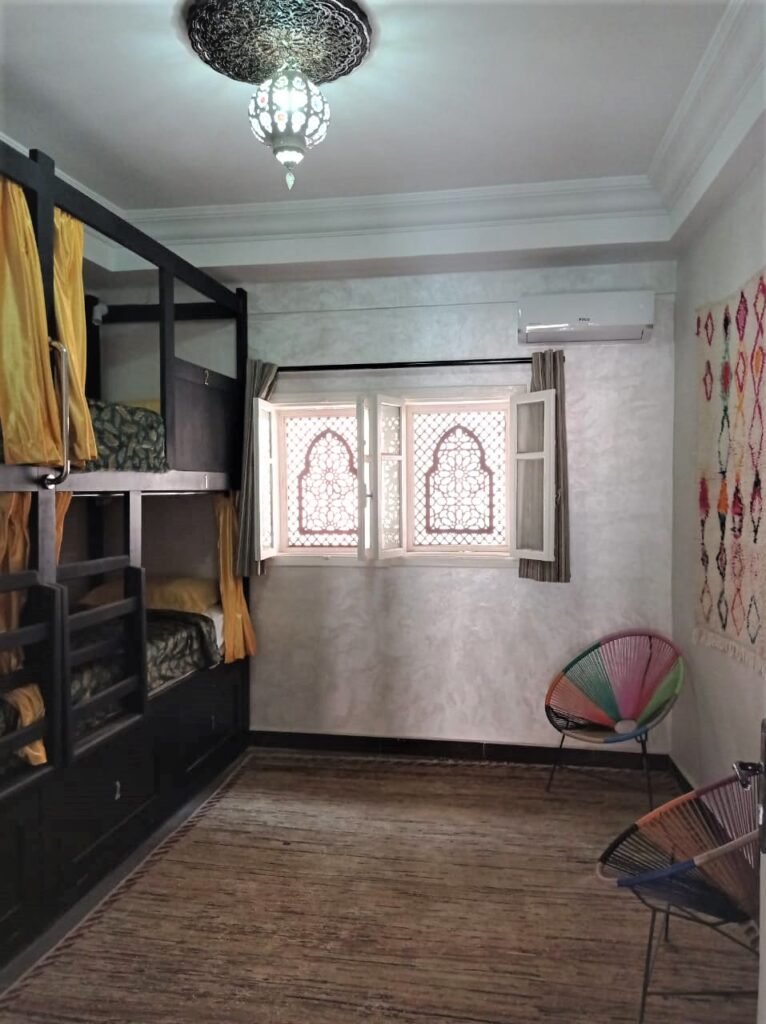 hostel room with two bunk beds and a window