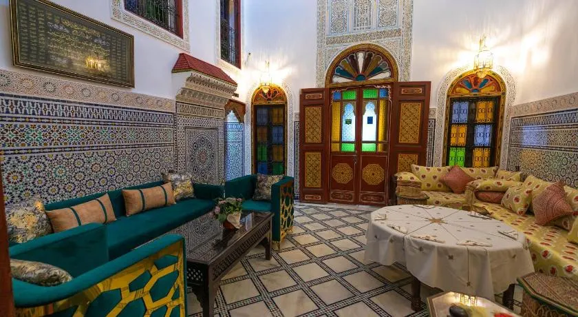 Traditional Fez living area with wooden doors and a green Moroccan style low couch