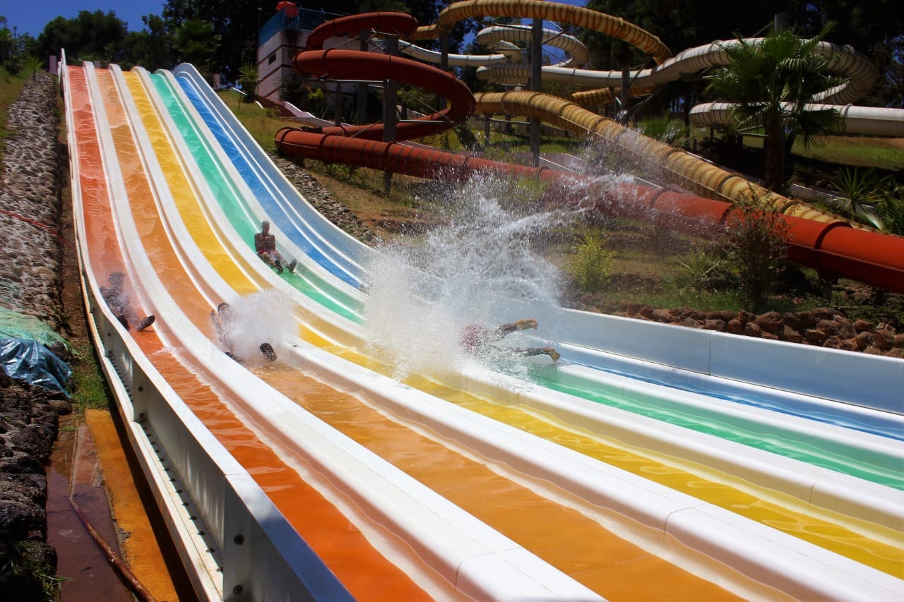 Rainbow colored water slides with people in Fes