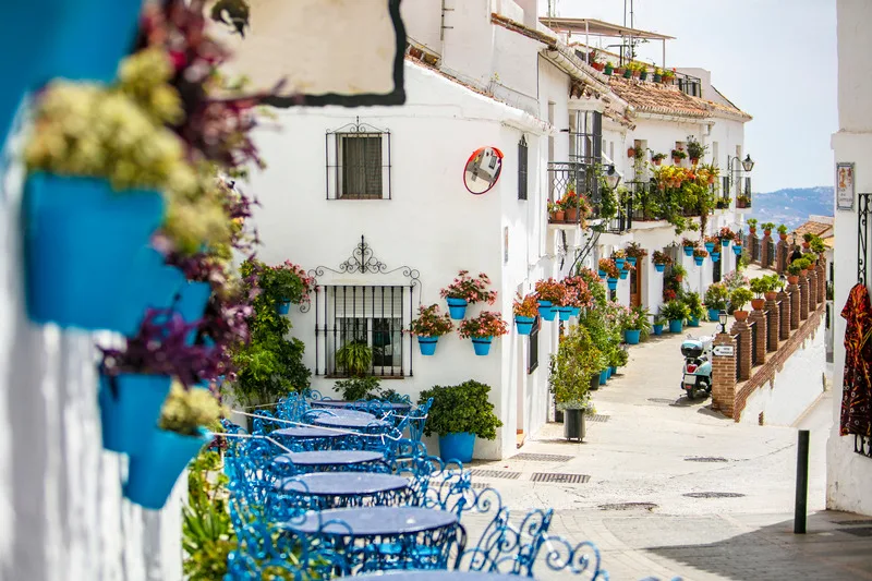 Beautiful street in Mijas with white houses decorated with colorful flower pots