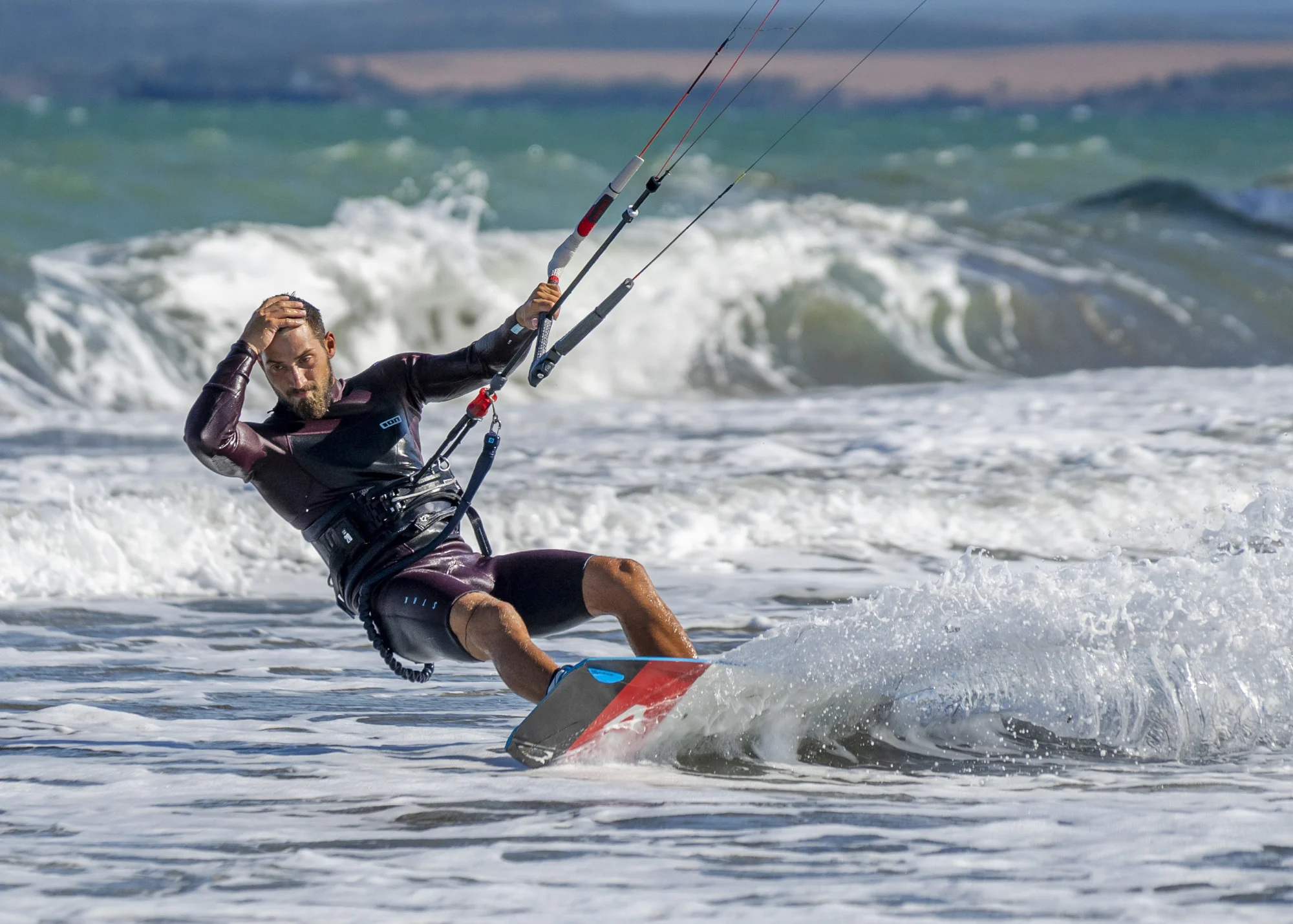 man on a kitesurfing board holding the kite