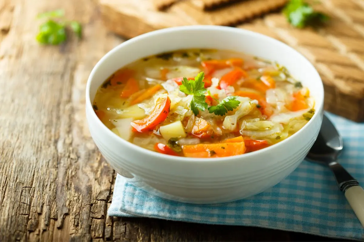 Vegan soup served in a white bowl on a wooden table