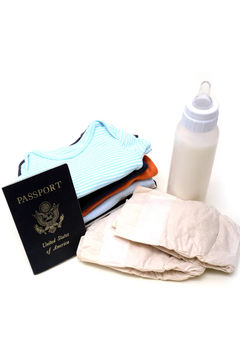 baby passport, clothes, diapers, and feeding bottle that things you need to survive an international with a baby