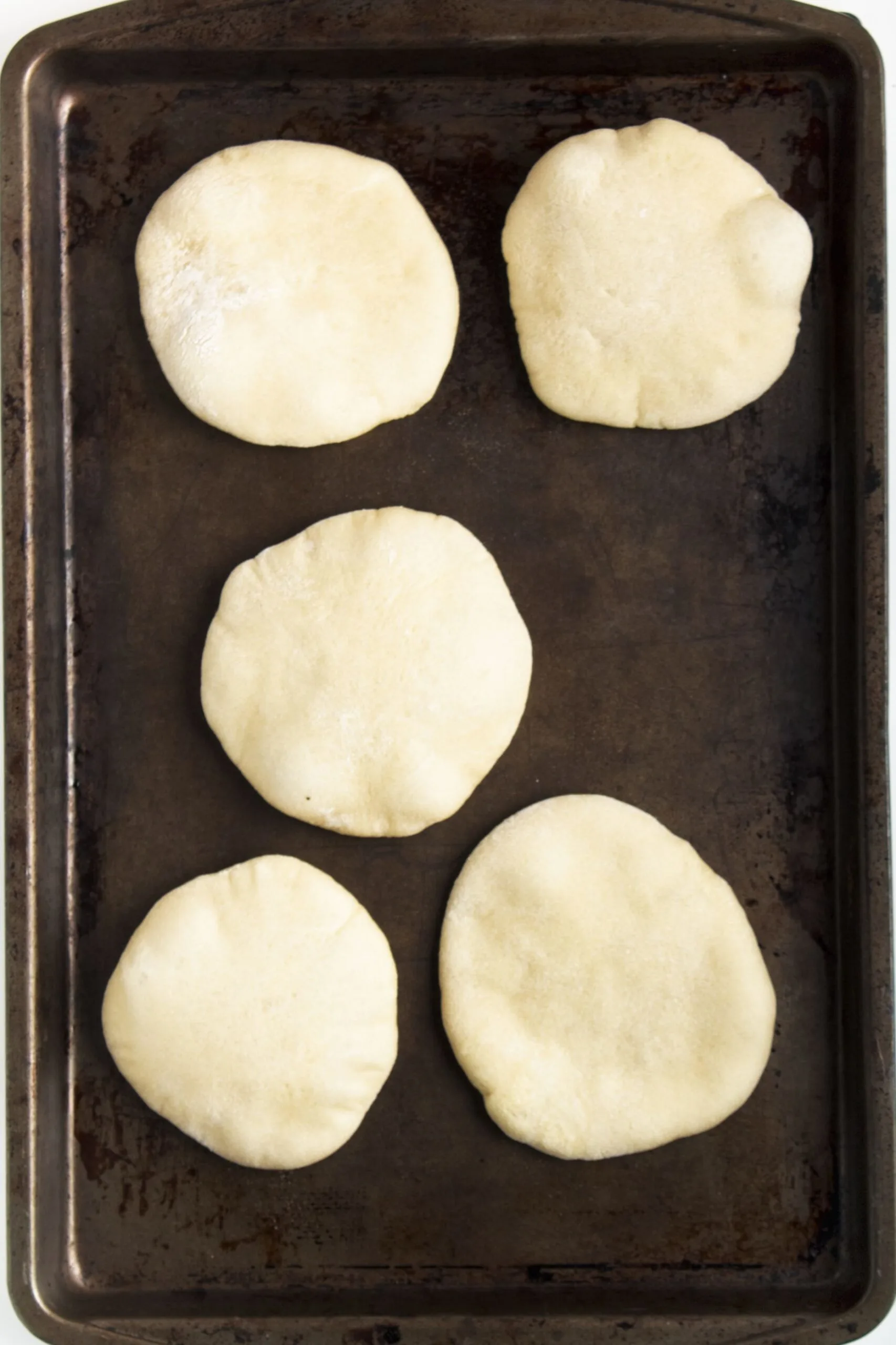 mini pita bread dough in a baking pan