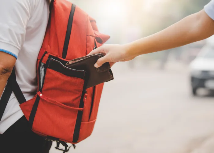 Person taking a wallet from someone's bag in an article about safety in Morocco