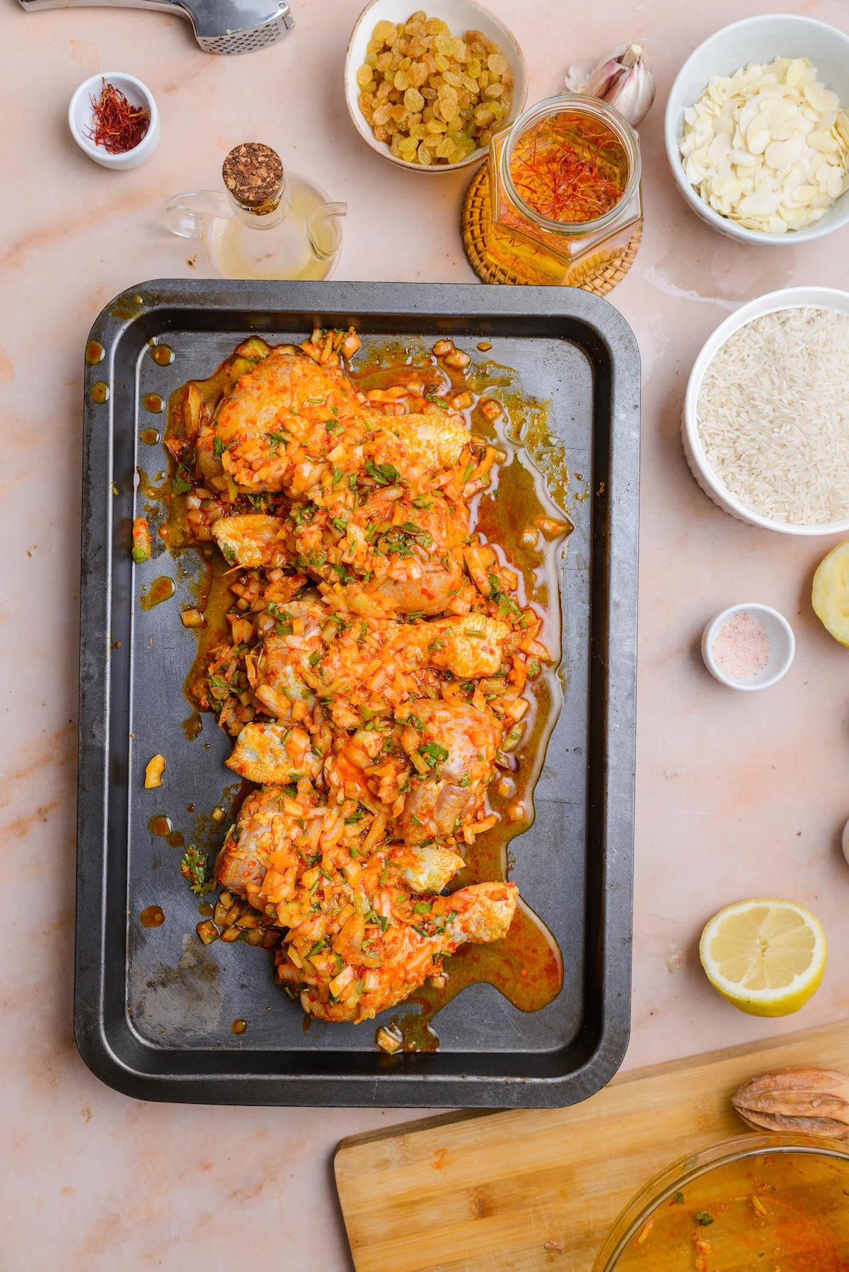 Marinated harissa chicken sits on a sheet pan.