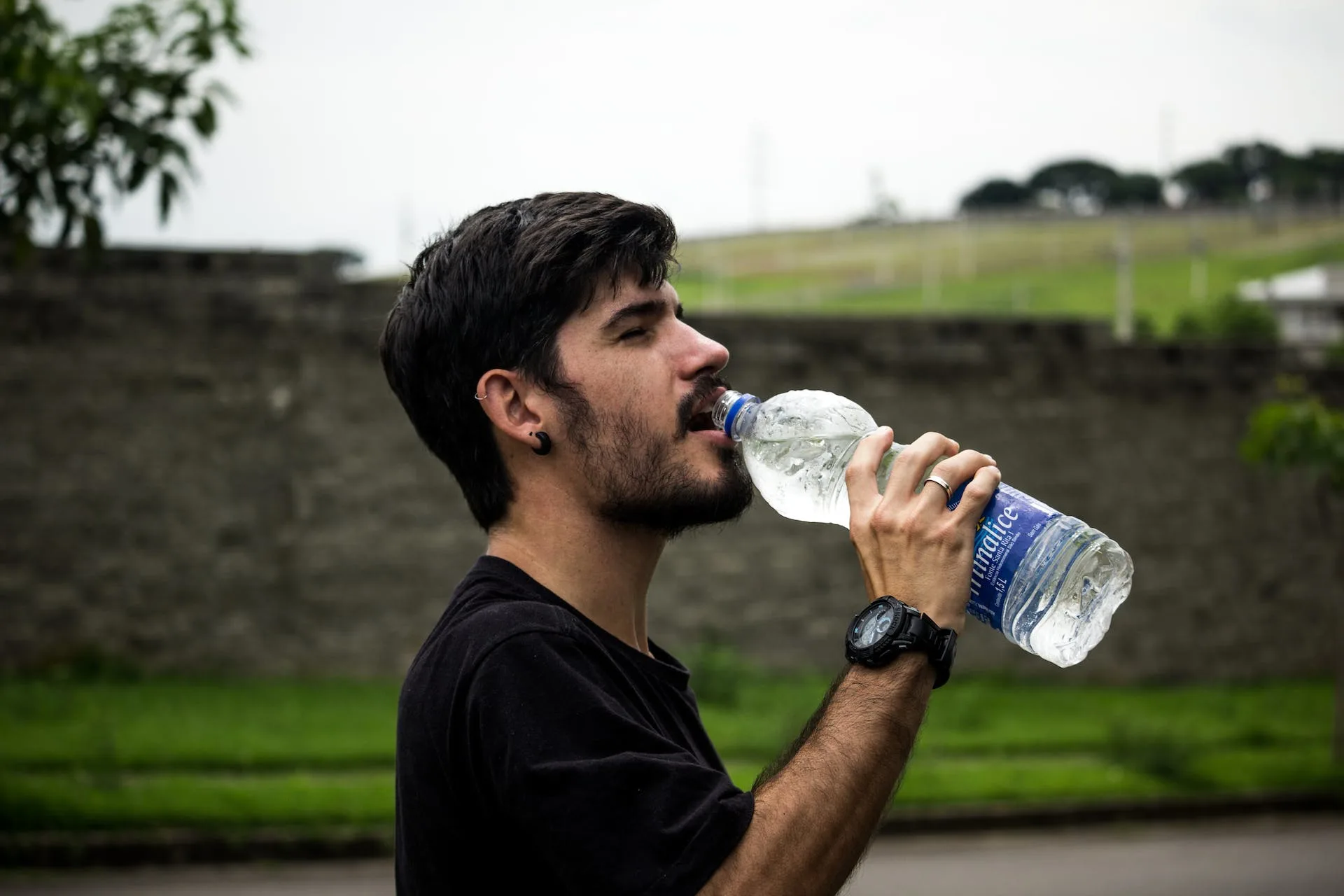 Man Wearing Black Shirt Drinking bottled Water