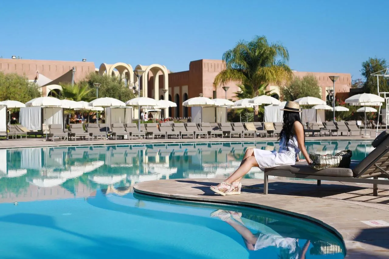 A woman lounging at the poolside area of Kenzi Club Agdal Medina in Marrakech