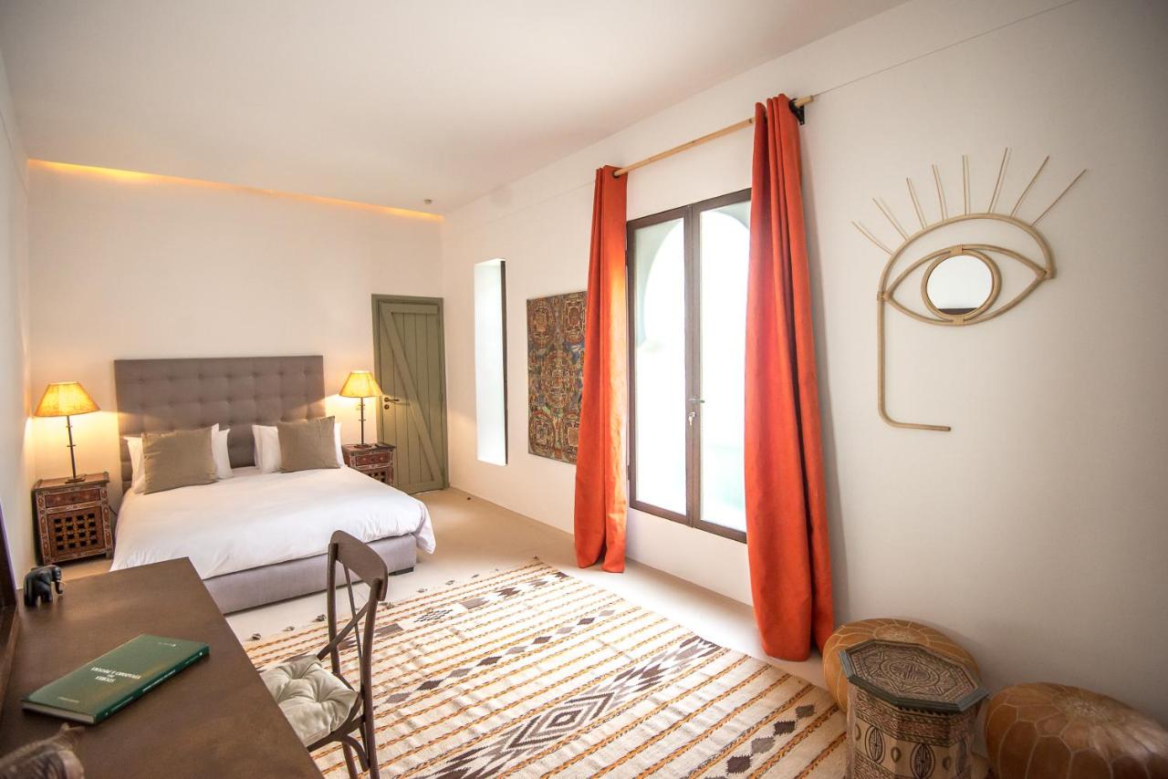 Inside a suite in Riad Alia with white beddings, a mixture of modern and Moroccan furnishings