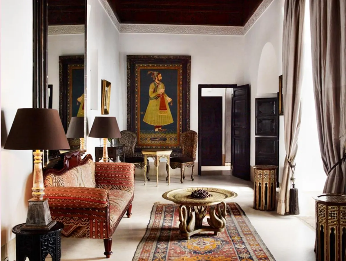 A suite in Riad L'Hôtel Marrakech individually decorated with an a artwork, tables and chairs
