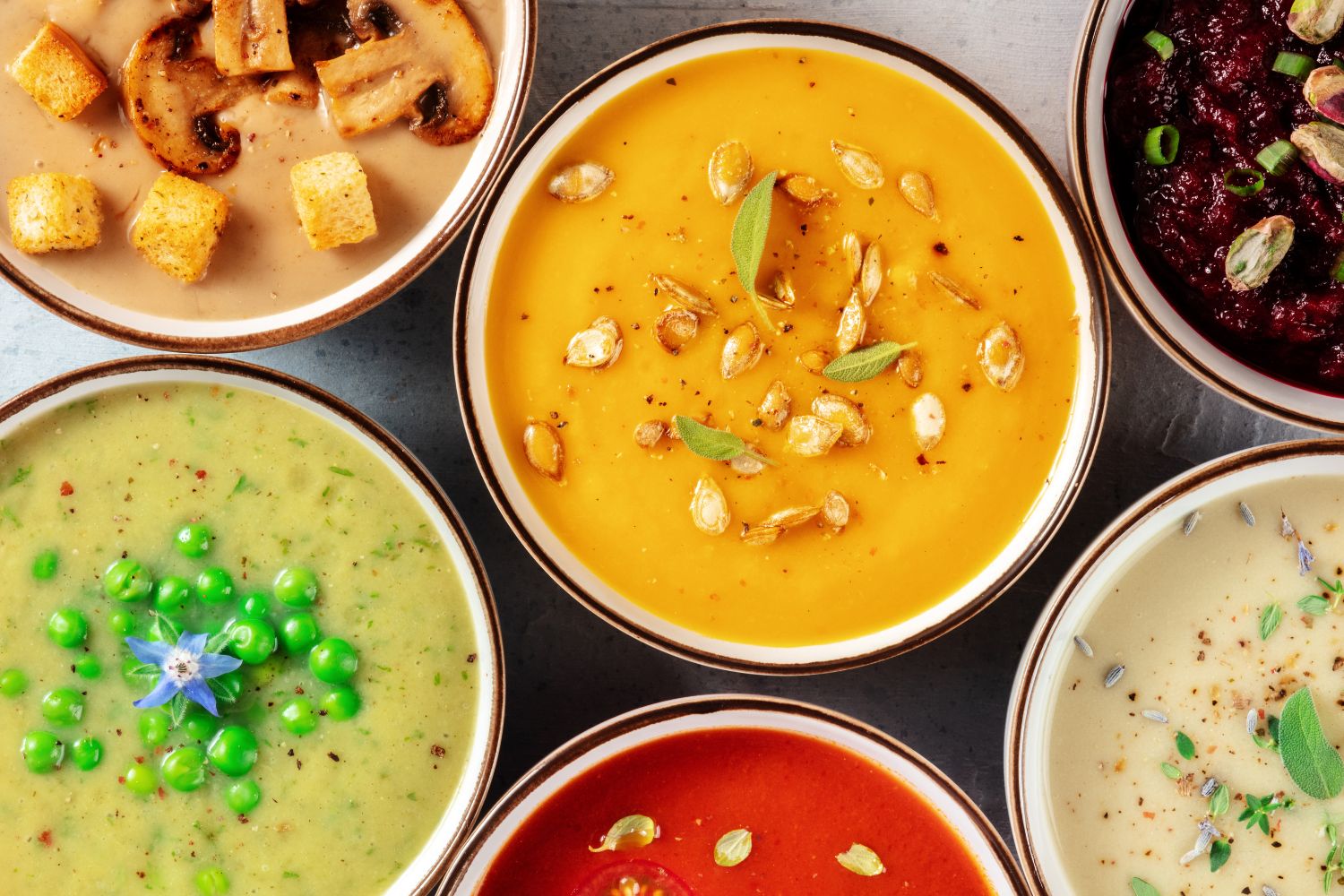 Overhead shot of various vegan soups served in bowls 