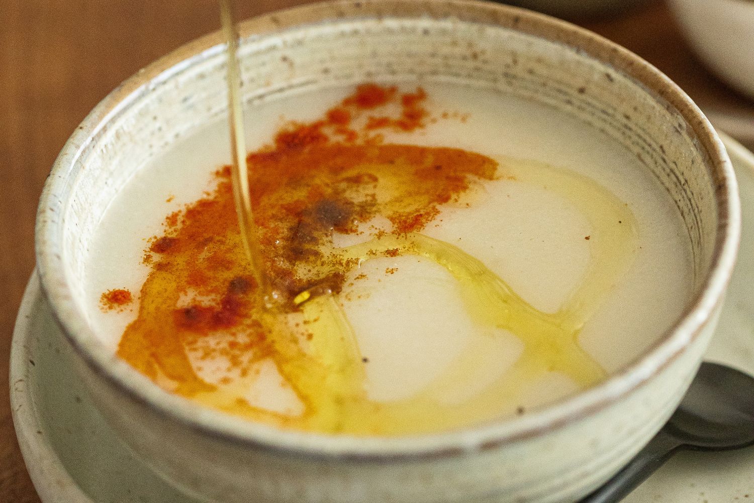 Mixing the ingredients in making Bissara in a white bowl