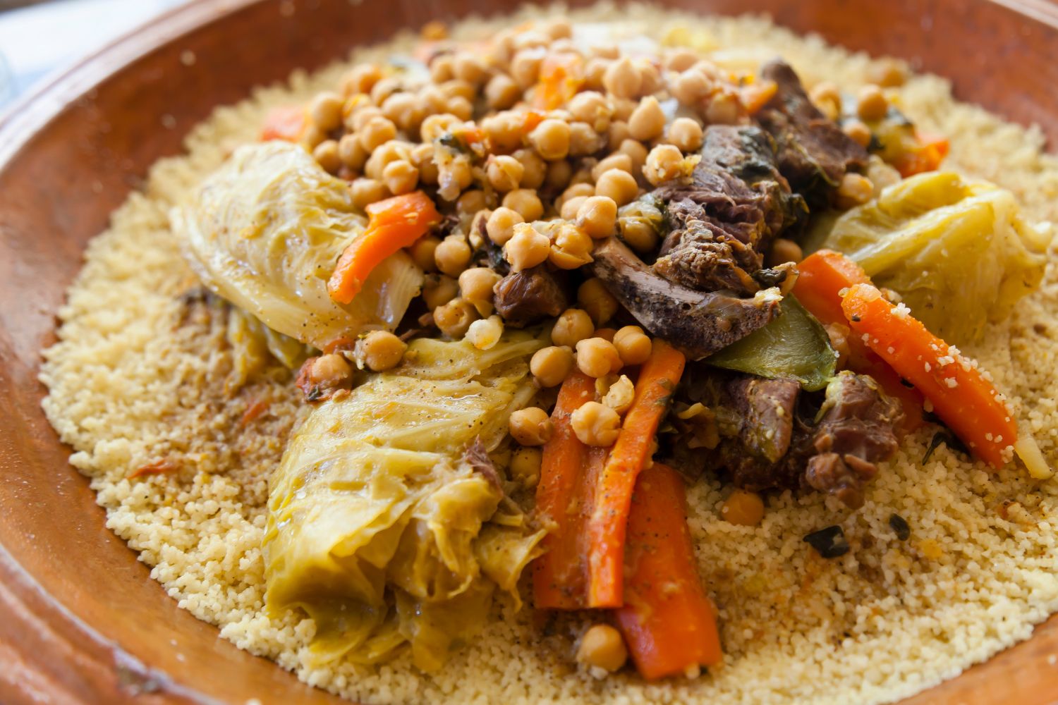 Couscous dish with vegetables and meat served in a brown plate