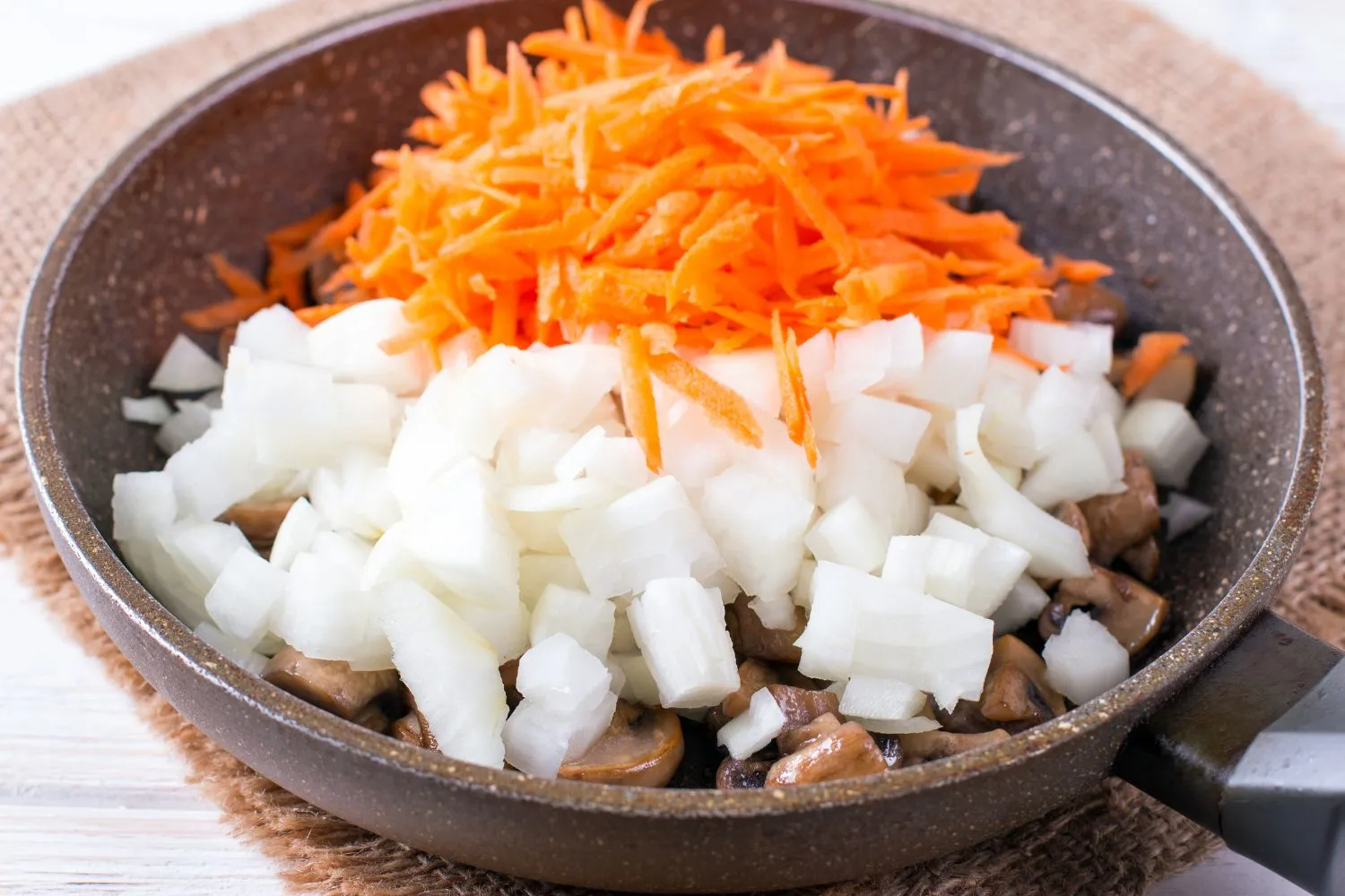 Slices of onions and carrots in a pan