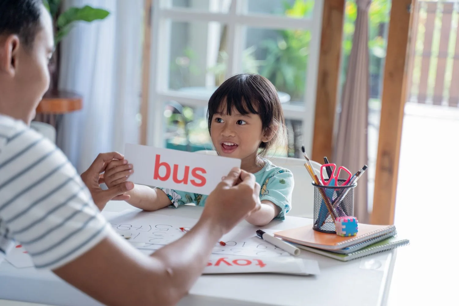 Dad teaching her daughter to read with flashcards