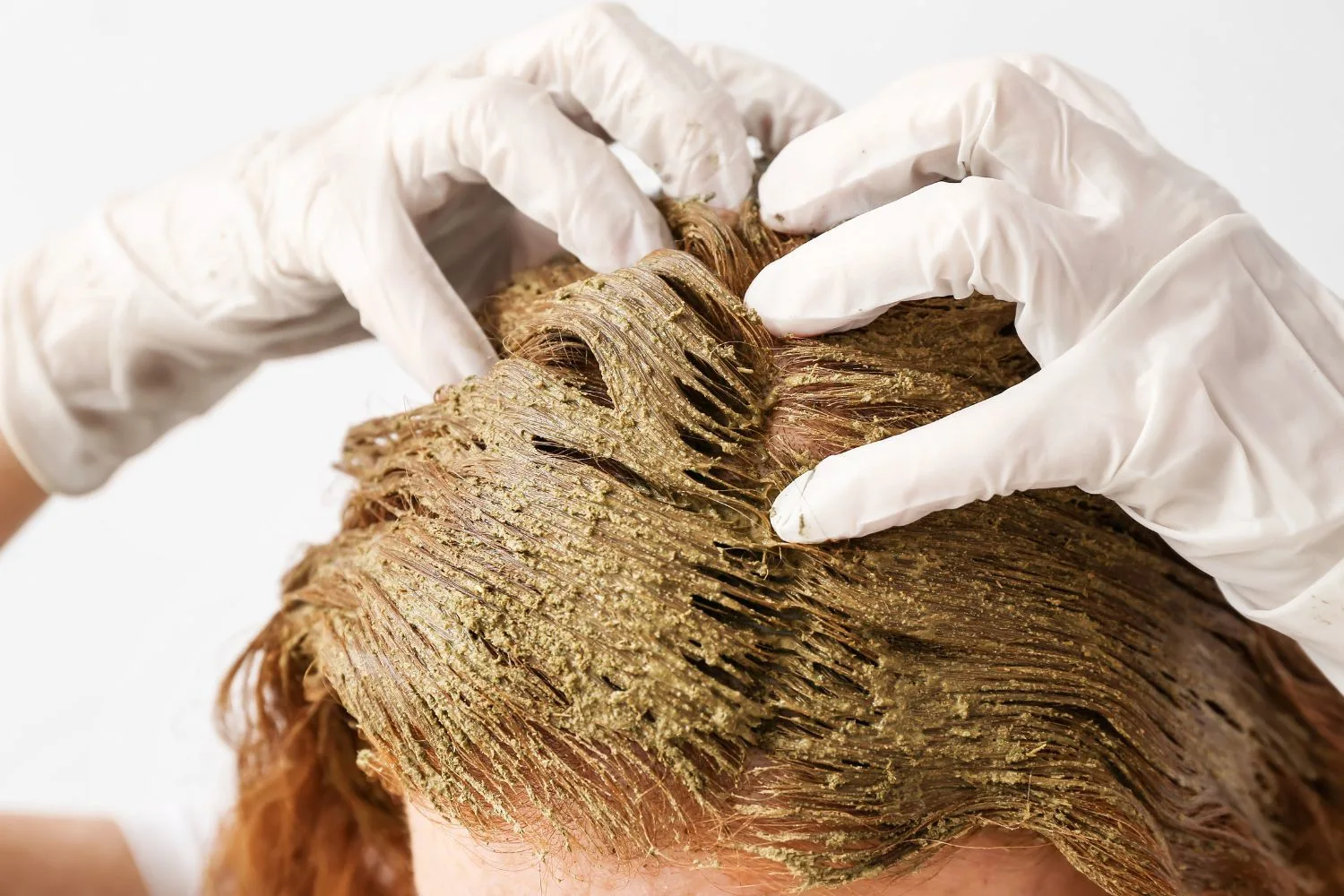 Young woman using henna hair dye 