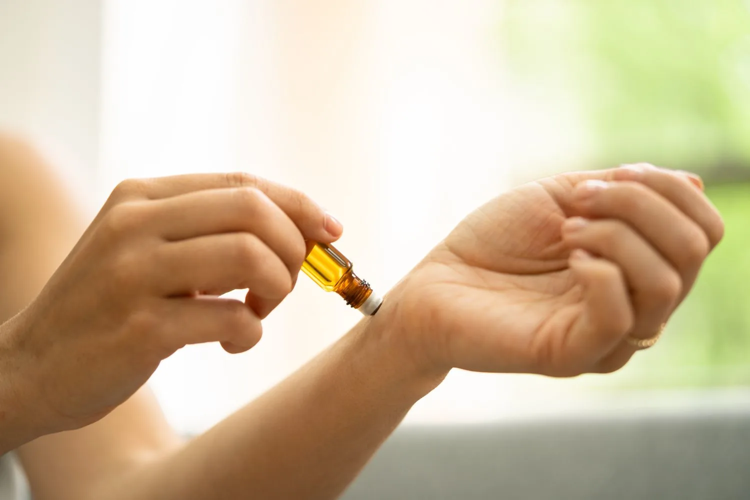 A woman applying argan oil to her skin