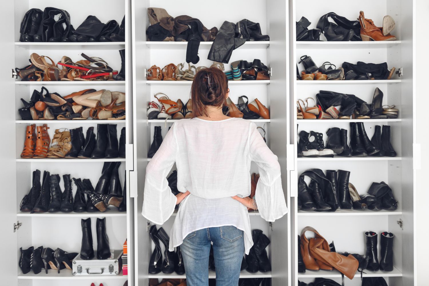Woman choosing shoes in her closet